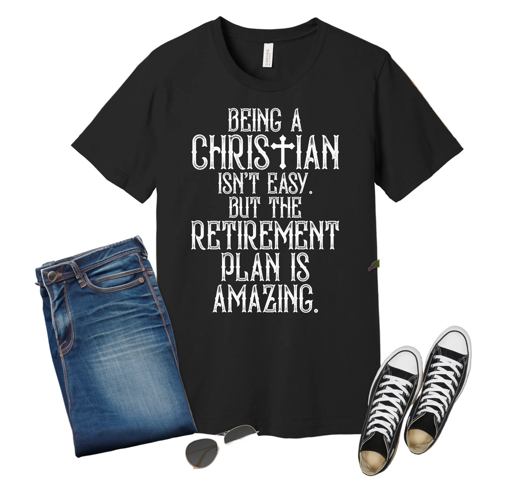 Black t-shirt with humorous text on a wooden surface with jeans, sneakers, and sunglasses.