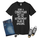 Black t-shirt with humorous text on a wooden surface with jeans, sneakers, and sunglasses.