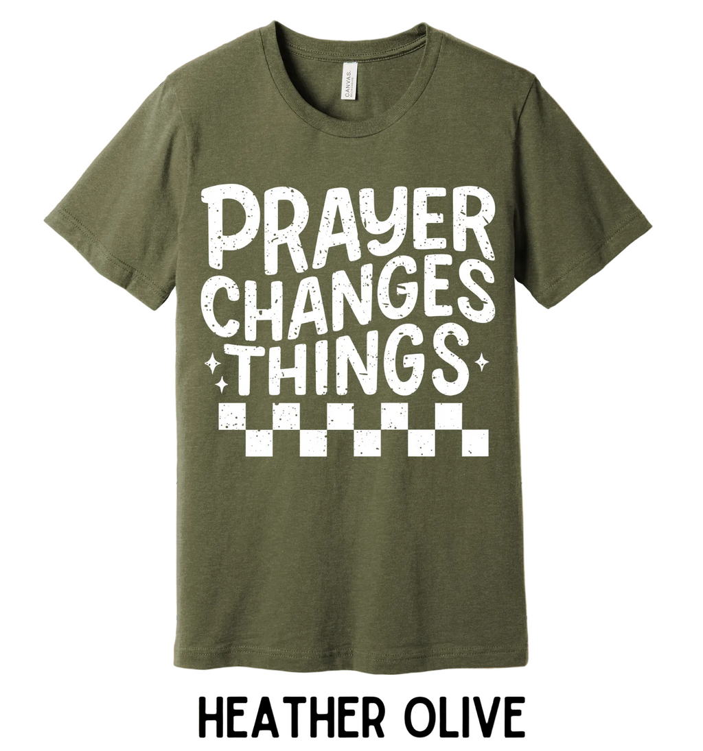 Green t-shirt with 'PRAYER CHANGES THINGS' text on a wooden background